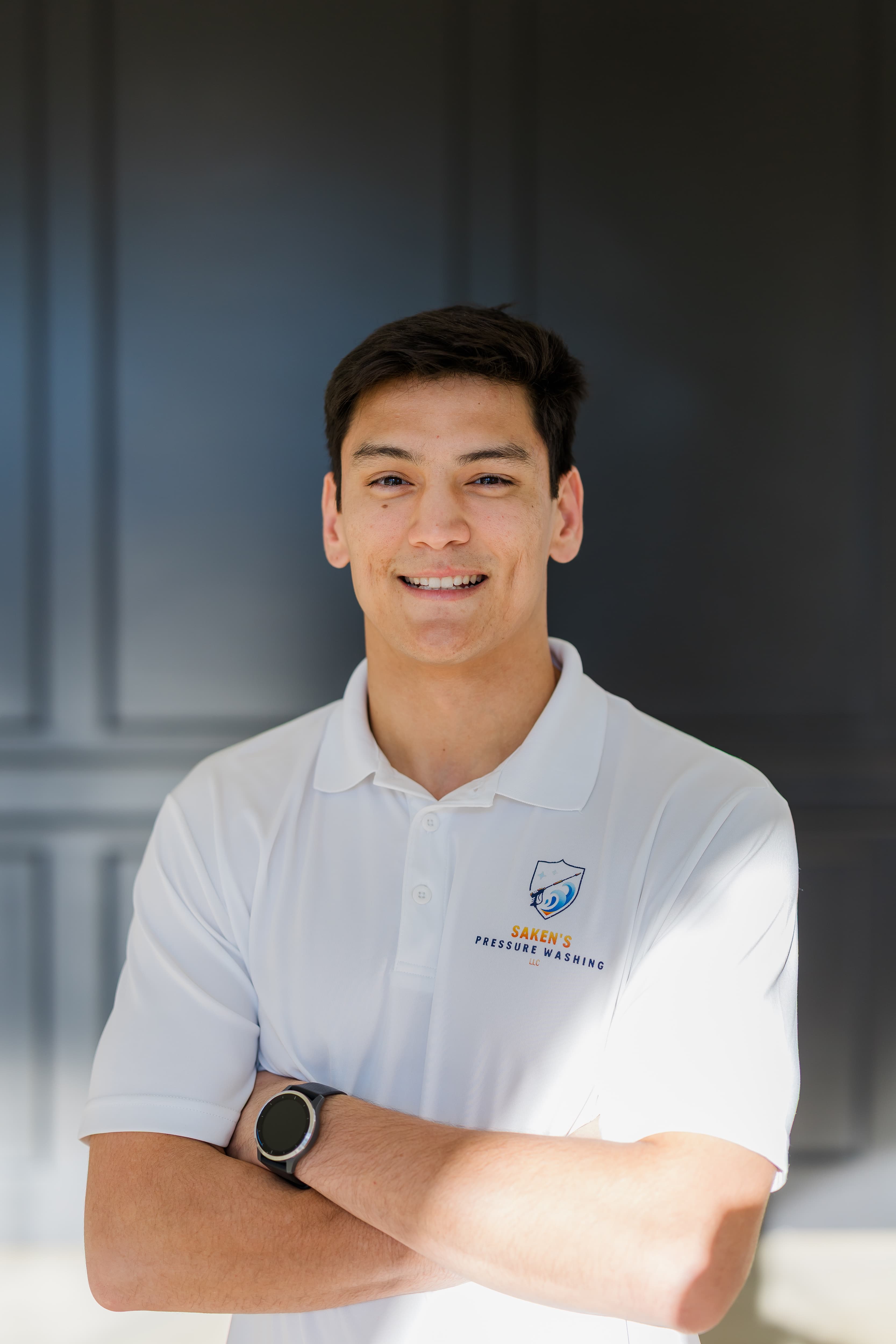 Saken Sawyer, owner of Saken's Pressure Washing, smiling in a company polo