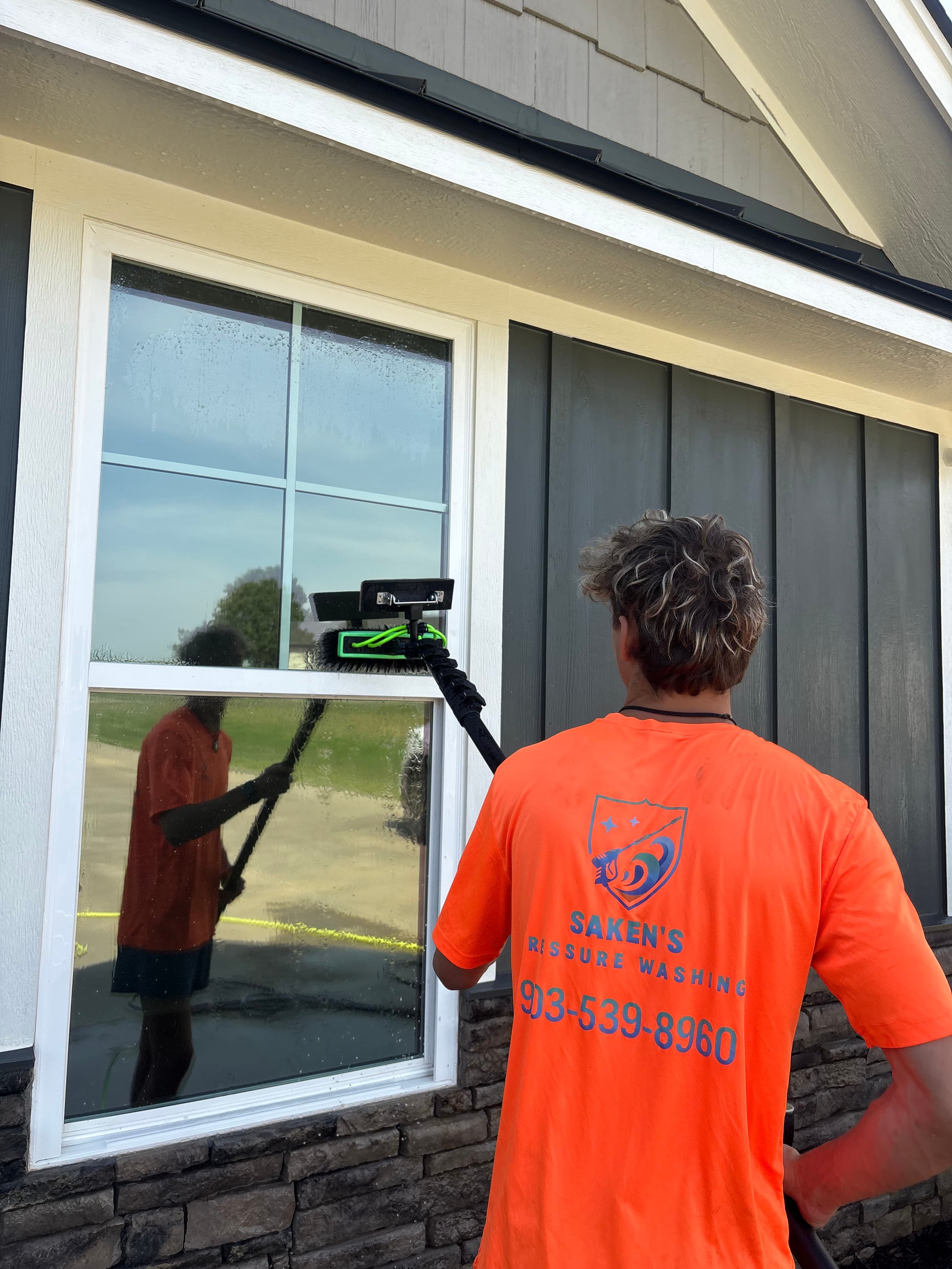 Crew member squeegeeing a front window