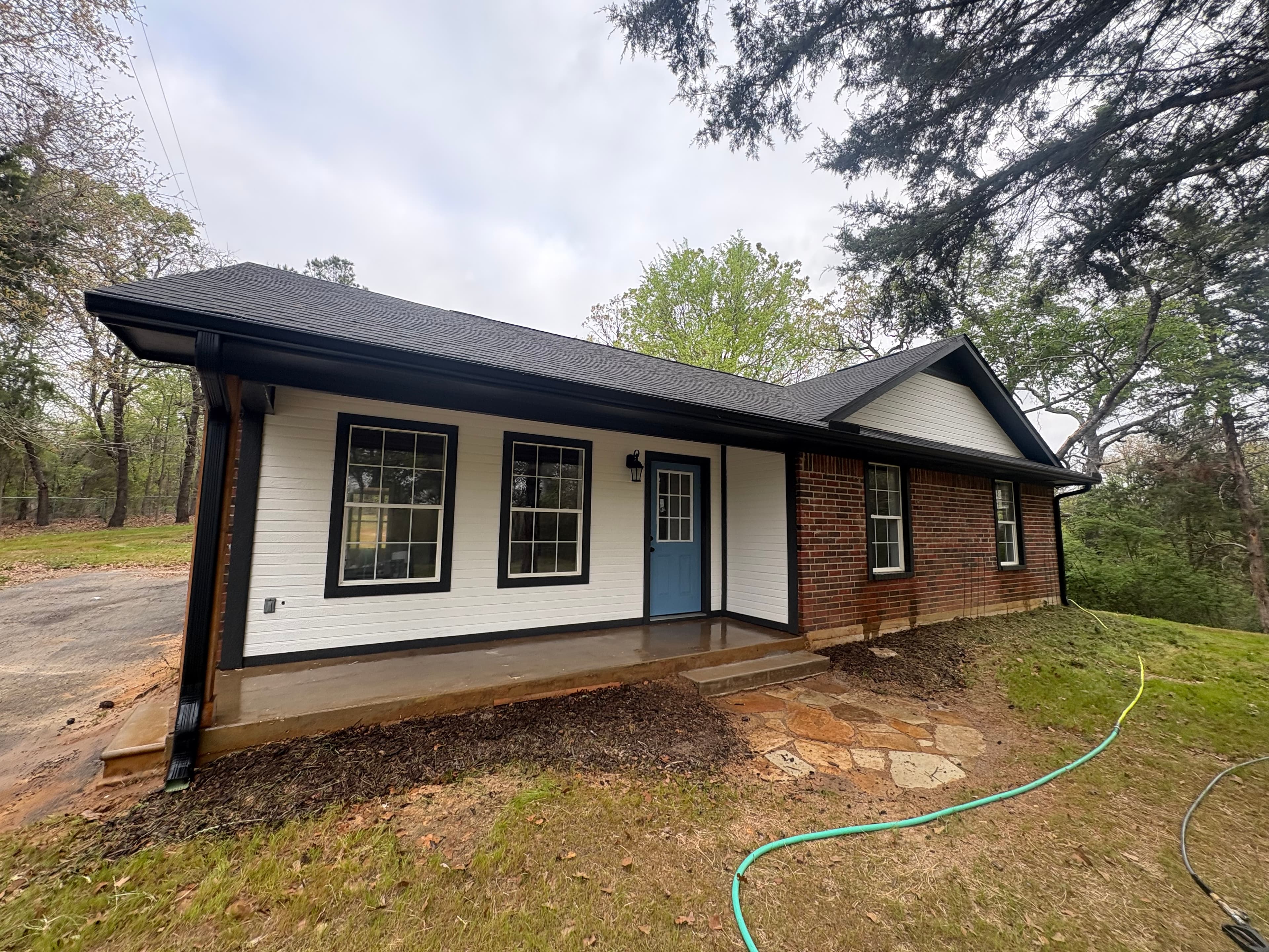 A newly built white brick and siding home after its cleanup
